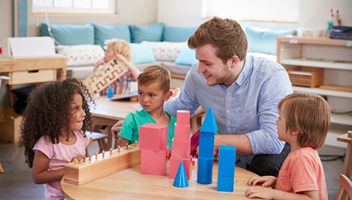 Foto von Kindern und ihrem Kita-Betreuer beim Spielen