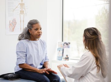 Foto von Frau im Gespräch mit einer Ärztin