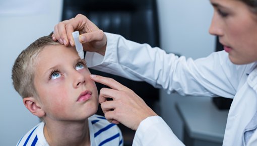 Foto von Kind, das mit Augentropfen behandelt wird