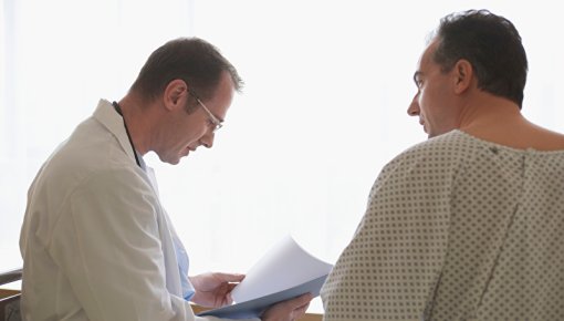 Foto von Arzt und Patient im Gespräch vor einer Operation