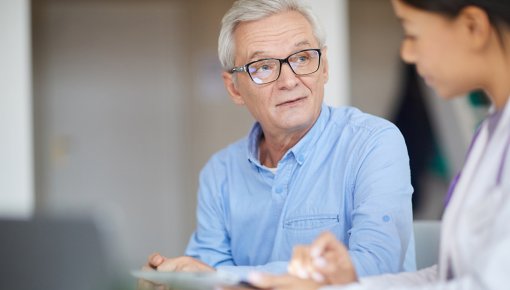 Das Foto zeigt einen Patienten im Gespräch mit einer Ärztin 