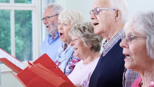 Gruppe von älteren Frauen und Männern beim Singen im Chor