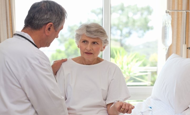 Foto von Patientin und Arzt am Krankenhausbett